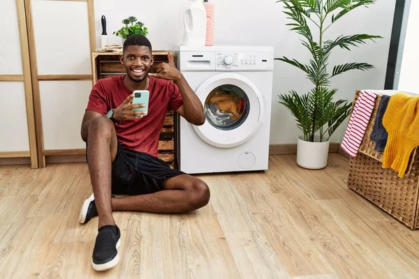 Young African American Man Using Smartphone Waiting Washing Machine Smiling — Zdjęcie stockowe