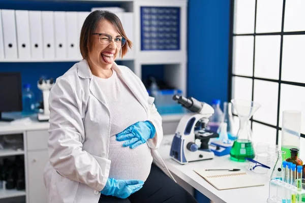 Беременная Женщина Работающая Научной Лаборатории Торчащая Языком Довольная Смешным Выражением — стоковое фото