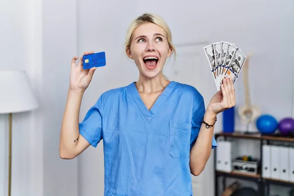 Νεαρή Φυσιοθεραπεύτρια Γυναίκα Που Κατέχει Πιστωτική Κάρτα Και Δολάρια Χαρτονομίσματα — Φωτογραφία Αρχείου