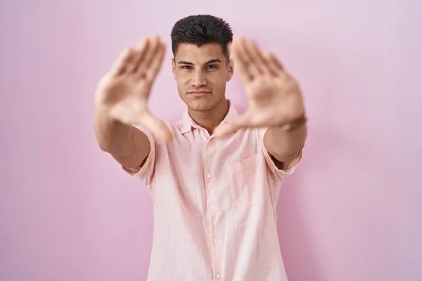 Mladý Hispánec Stojící Nad Růžovým Pozadím Dělá Rám Pomocí Dlaní — Stock fotografie