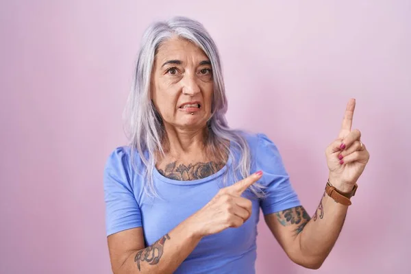 Mujer Mediana Edad Con Tatuajes Pie Sobre Fondo Rosa Señalando — Foto de Stock