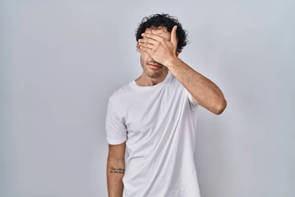 Homem Hispânico Sobre Fundo Isolado Cobrindo Olhos Com Mão Olhando — Fotografia de Stock