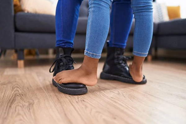 Father and daughter stepping on foot dancing at home