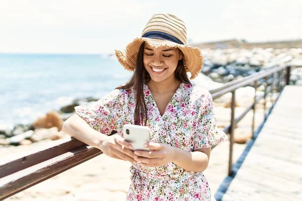 모자를 해변에서 스마트폰을 — 스톡 사진