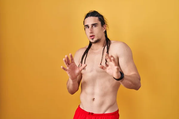 Hispanic Man Long Hair Standing Shirtless Yellow Background Afraid Terrified — Stockfoto