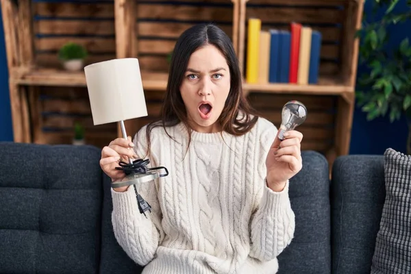 Young Brunette Woman Holding Led Lightbulb Lamp Shock Face Looking — Stock Photo, Image