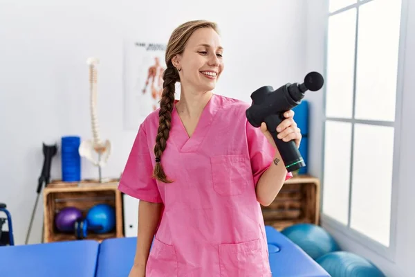Молода Біла Жінка Уніформі Фізіотерапевта Тримає Ударний Пістолет Клініці Фізіотерапії — стокове фото