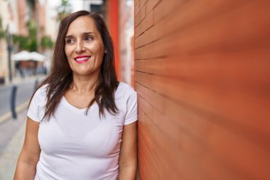 Young beautiful hispanic woman smiling confident looking to the side at street