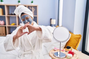 Siyah saçlı, güzel maske takan, aşık bir İspanyol kadın. Elleriyle kalp sembolü ve şekli gösteriyor. romantik kavram. 