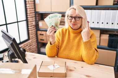 Orta yaşlı, beyaz bir kadın, elinde Hong Kong dolarlarıyla küçük işletmelerde çalışıyor. Elinde bir fikir ya da soruyla gülümsüyor. 