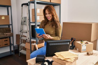 Ofiste dokunmatik ped kullanan genç Latin bir iş kadını.