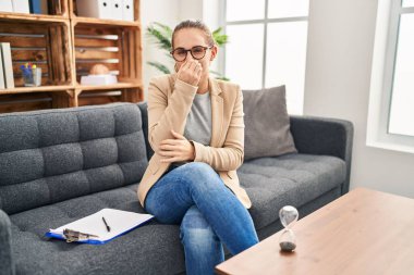 Muayenehanede çalışan genç bir kadın pis ve iğrenç bir koku alıyor. Nefesini burnunda tutuyor. Kötü kokuyor. 