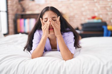 Young beautiful hispanic woman lying on bed crying at bedroom