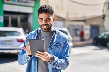 Sokakta dokunmatik ped kullanan, kendine güvenen İspanyol genç adam.