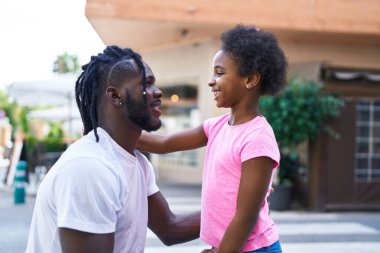 Father and daughter smiling confident standing together at coffee shop terrace