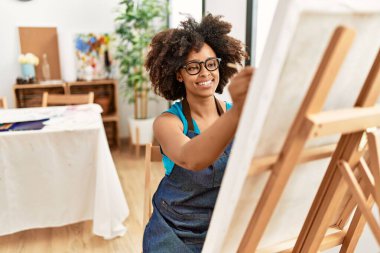 Genç Afrikalı Amerikalı kadın sanat stüdyosunda kendine güvenen bir çizim yapıyor.
