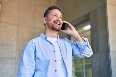 Kafkasyalı genç adam gülümsüyor. Kendine güvenen caddedeki akıllı telefondan konuşuyor.