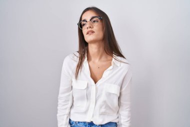 Young brunette woman wearing glasses looking sleepy and tired, exhausted for fatigue and hangover, lazy eyes in the morning. 