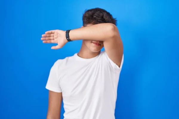 Ισπανόφωνος Έφηβος Στέκεται Πάνω Από Μπλε Φόντο Καλύπτει Μάτια Χέρι — Φωτογραφία Αρχείου