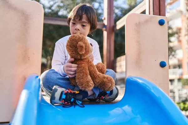 Dzieciak Zespołem Downa Bawiący Się Misiaczkiem Zjeżdżalni Parku — Zdjęcie stockowe