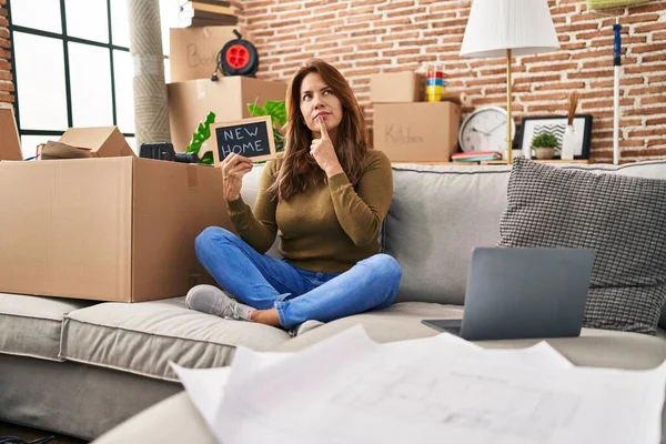Hispanic Woman Moving New Home Serious Face Thinking Question Hand — Stockfoto