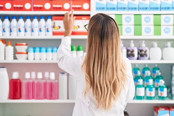 年轻的金发女药剂师站在药店的后视镜上 — 图库照片