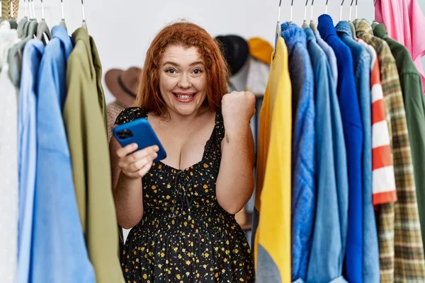 Junge Rothaarige Frau Sucht Kleidung Auf Kleiderständern Mit Smartphone Schreit — Stockfoto