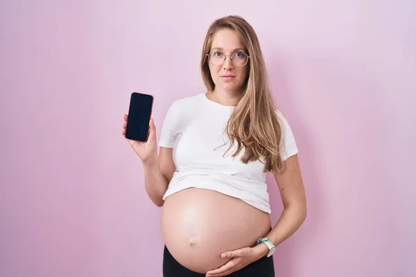 Jonge Zwangere Vrouw Toont Buik Houden Smartphone Ontspannen Met Serieuze — Stockfoto