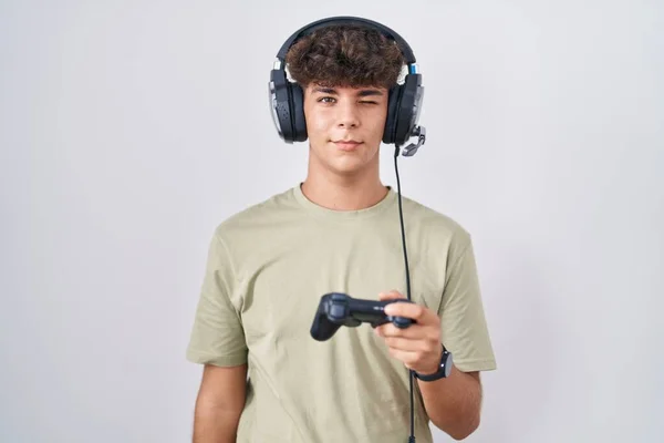 Hispanic Teenager Playing Video Game Holding Controller Winking Looking Camera — Stock Photo, Image