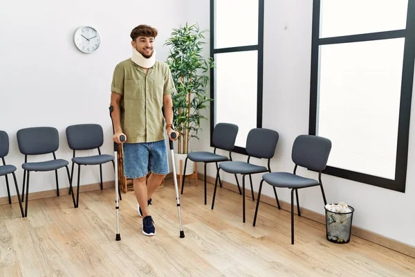 Young Arab Man Wearing Neck Collar Standing Using Crutches Hospital — Stock Photo, Image