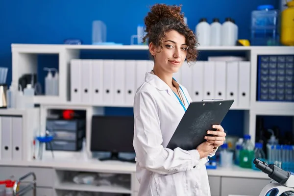 Young Hispanic Woman Scientist Smiling Confident Reading Document Laboratory — Stockfoto