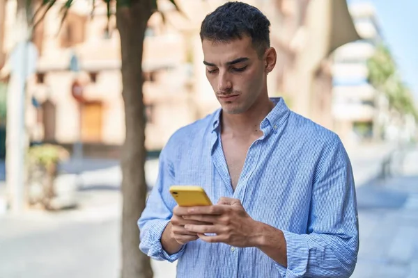 Ung Latinamerikansk Man Använder Smartphone Med Allvarliga Uttryck Gatan — Stockfoto