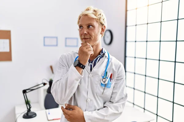 Young Blond Man Wearing Doctor Uniform Stethoscope Clinic Looking Confident — Photo