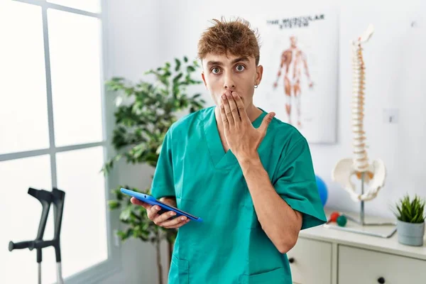 Young Caucasian Physio Man Using Touchpad Clinic Covering Mouth Hand — Stok fotoğraf
