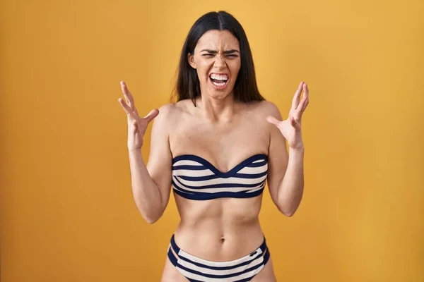 Sarı Arka Plan Üzerine Bikini Giyen Genç Esmer Kadın Kızgın — Stok fotoğraf