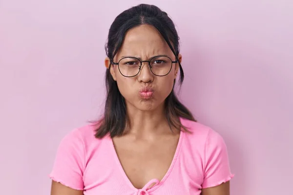Hispanic Young Woman Standing Pink Background Wearing Glasses Puffing Cheeks — Zdjęcie stockowe