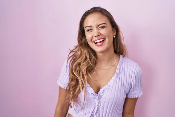 Young Hispanic Woman Standing Pink Background Winking Looking Camera Sexy — kuvapankkivalokuva