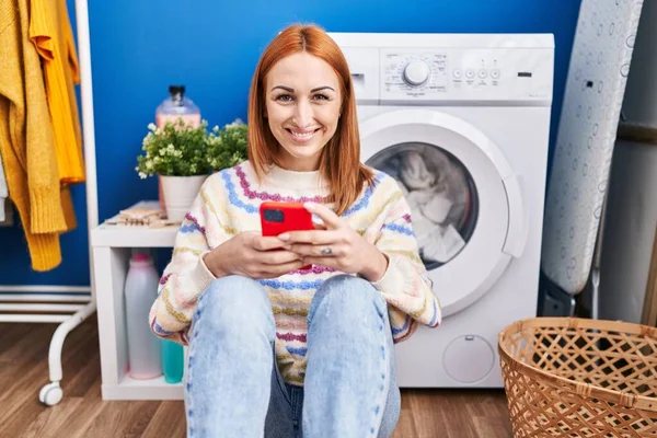 Ung Kaukasisk Kvinna Med Smartphone Väntar Tvättmaskin Tvättstugan — Stockfoto