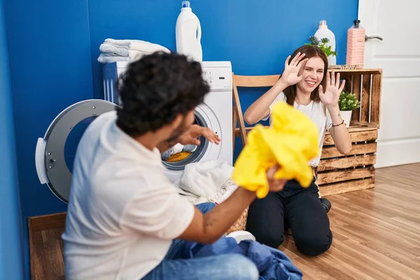 Man Woman Couple Smiling Confident Playing Cleaning Clothes Laundry Room — Stockfoto