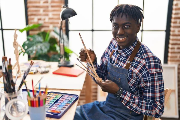 非洲裔美国人艺术家带着自信的笑容在艺术工作室里手握画笔 — 图库照片