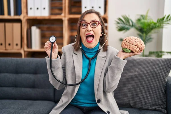 Mujer Hispana Mediana Edad Trabajando Oficina Terapia Sosteniendo Cerebro Celebrando — Foto de Stock