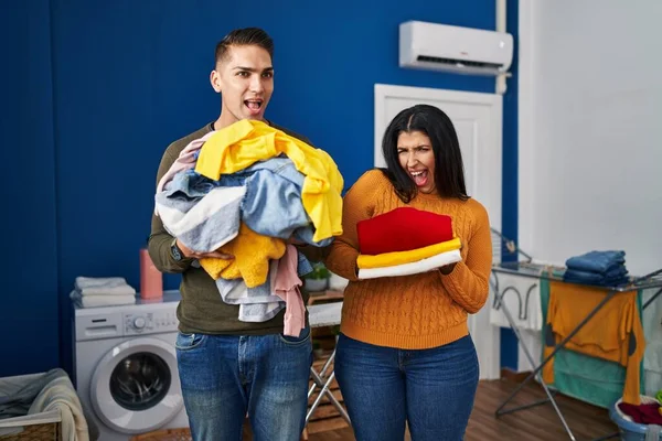 Young Couple Holding Laundry Dirty Clean Laundry Celebrating Crazy Amazed — Zdjęcie stockowe