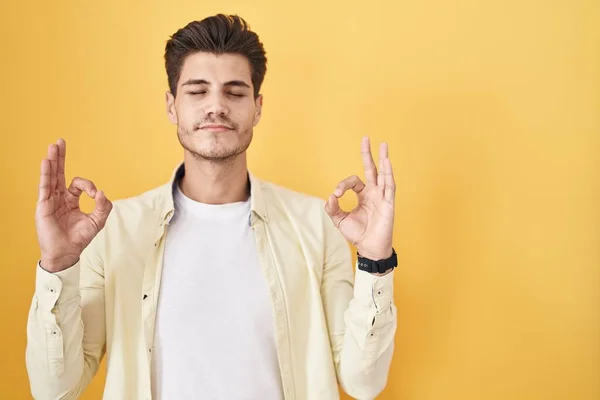 Sarı Arka Planda Duran Genç Spanyol Adam Rahatlamış Parmaklarıyla Meditasyon — Stok fotoğraf