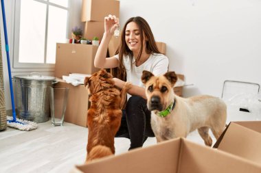 Genç İspanyol kadın gülümsüyor. Yeni evin anahtarını elinde tutuyor.