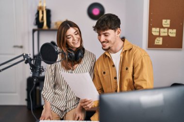 Mand and woman musicians singing song at music studio