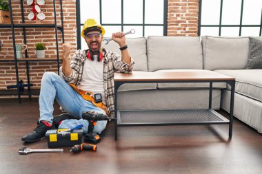 Sakallı genç İspanyol adam hareketli serviste çalışıyor. Gururla bağırıyor, zaferi kutluyor ve kollarını kaldırarak başarıyı kutluyor. 