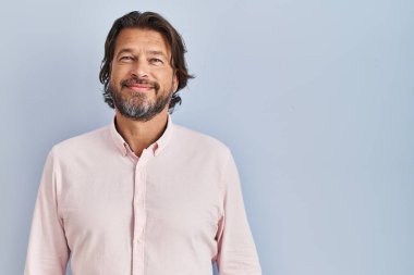 Yakışıklı, orta yaşlı, zarif gömlekli, yüzünde mutlu ve havalı bir gülümseme olan bir adam. şanslı kişi. 