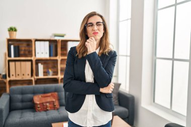 Muayenehanede çalışan genç bir kadın şüphe üzerine yoğunlaşmıştı. Parmakları çenesinde ve yukarı bakıyordu. 