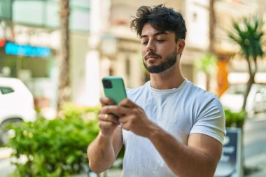 Sokakta akıllı telefon kullanan genç bir İspanyol.