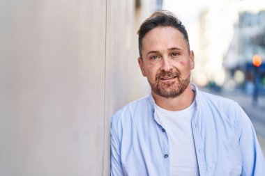 Young caucasian man smiling confident standing at street